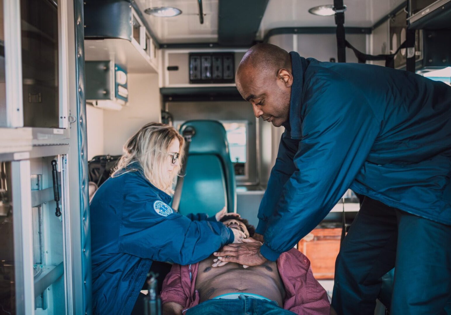 Two personnel doing CPR on a guy